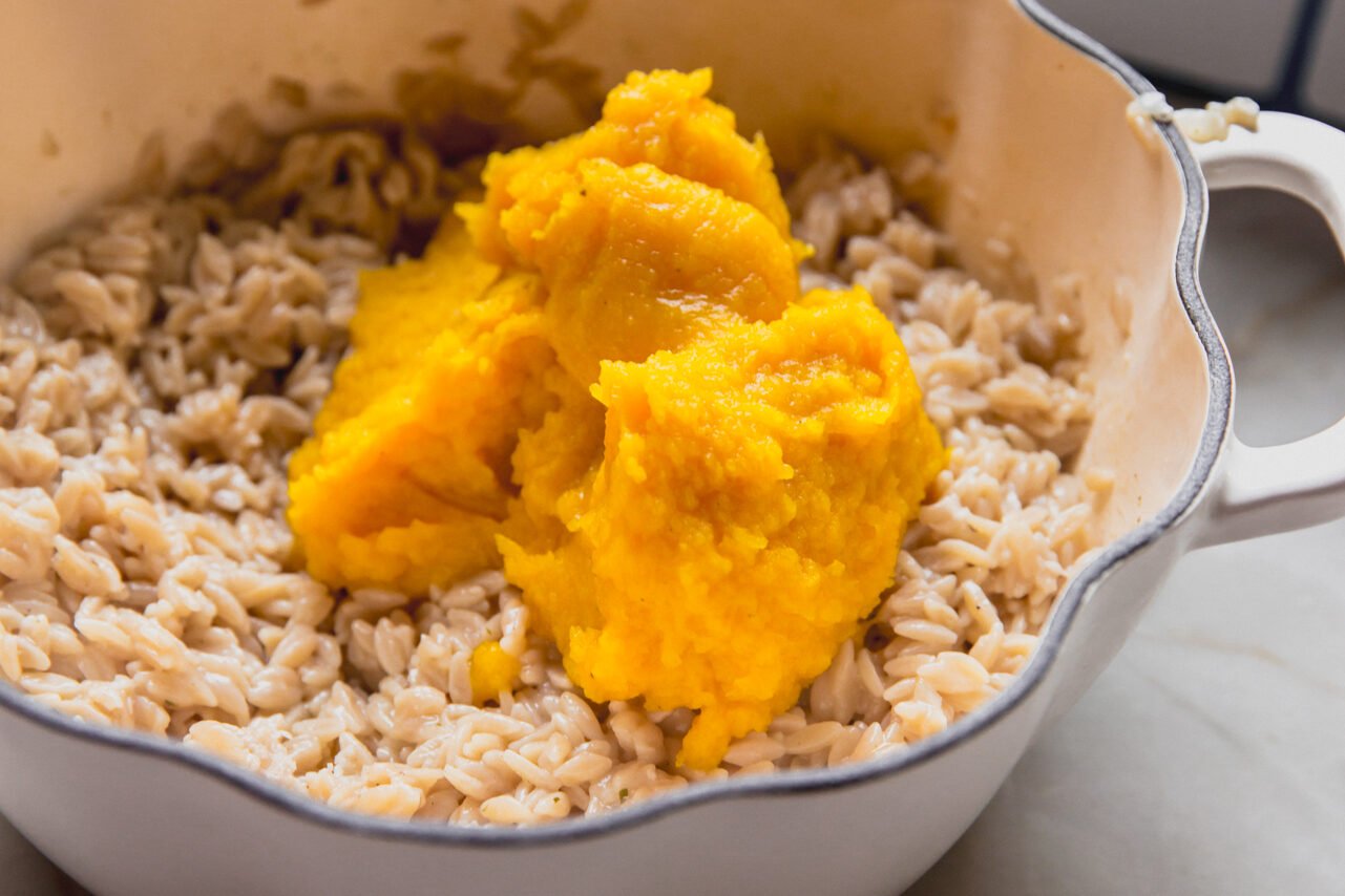 A pot with the cooked orzo and pumpkin puree before mixing.