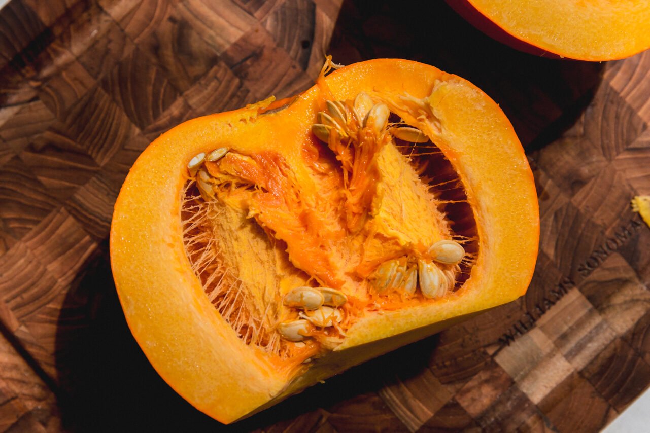 Half of a sugar pumpkin after being sliced in half.