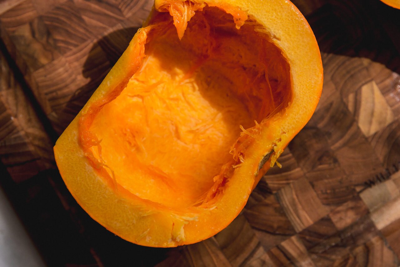 Half of the sugar pumpkin with seeds removed and topped with avocado oil.