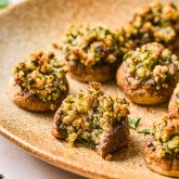 Stuffed mushrooms on a platter with a bite taken out of one.