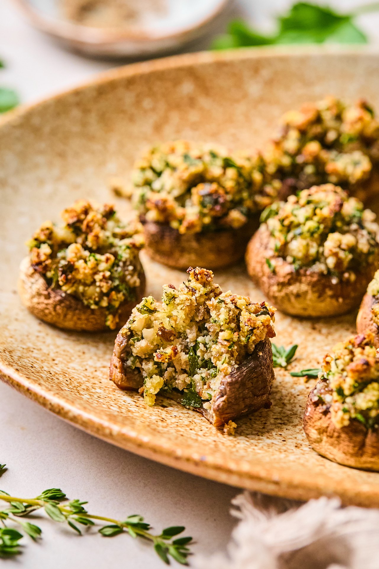 Stuffed mushrooms on a platter with a bite taken out of one.