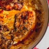 Turkey cutlets with an orange glaze in a large pan.