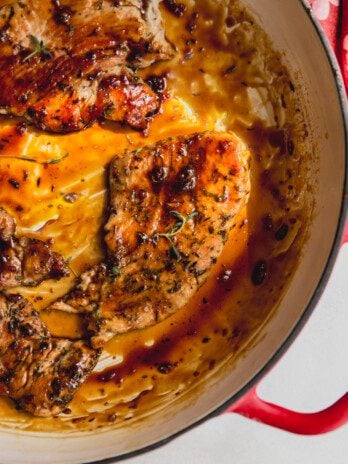 Turkey cutlets with an orange glaze in a large pan.