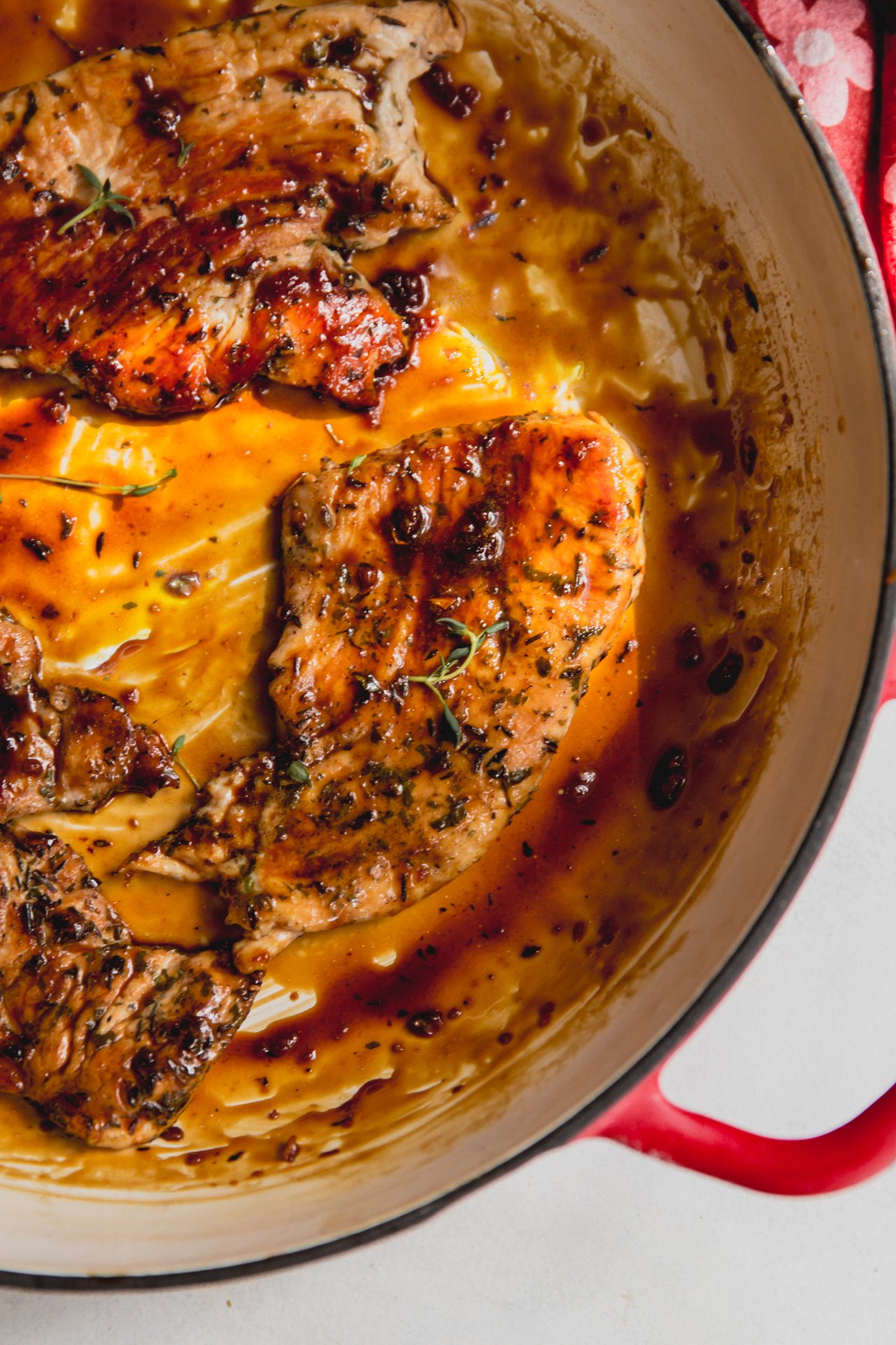 Turkey cutlets with an orange glaze in a large pan. 