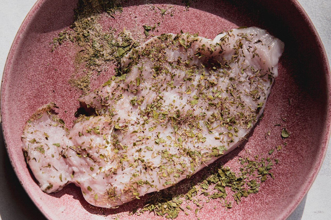 Raw tureky cutlet seasoned with herbs.