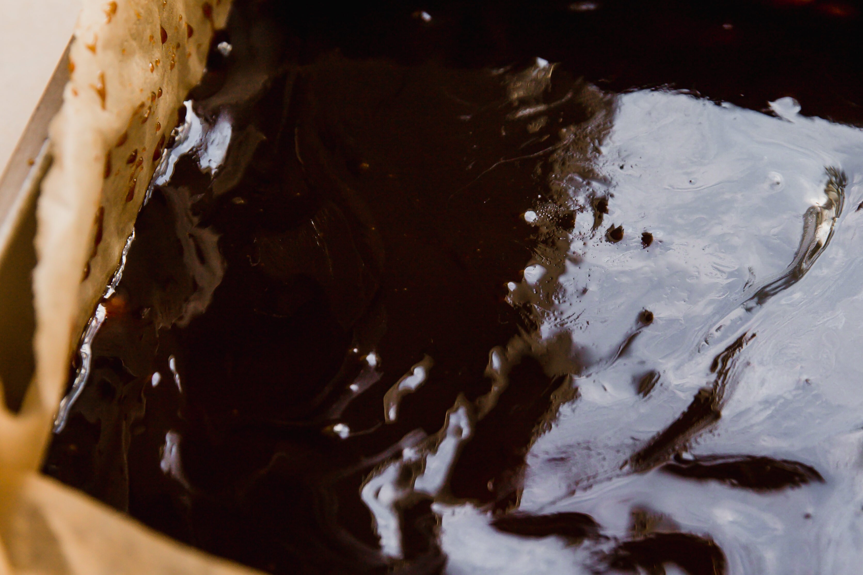 Shortbread topped with caramel in a baking pan.