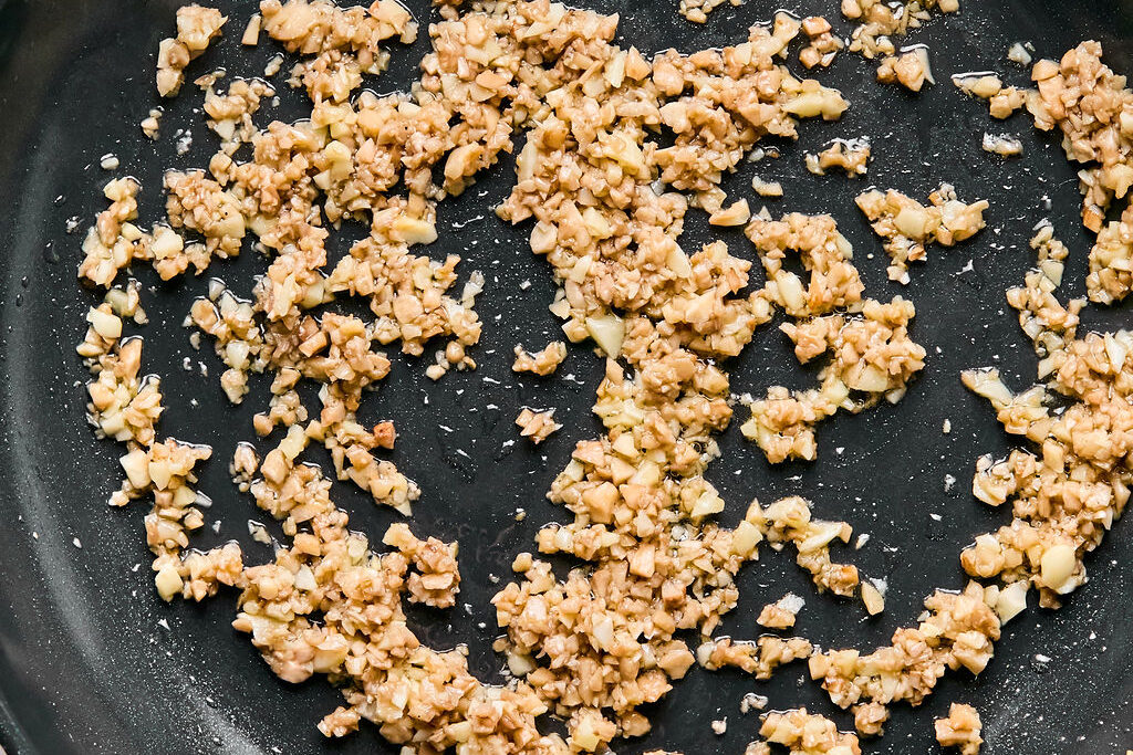 A pan with garlic sauting in it.