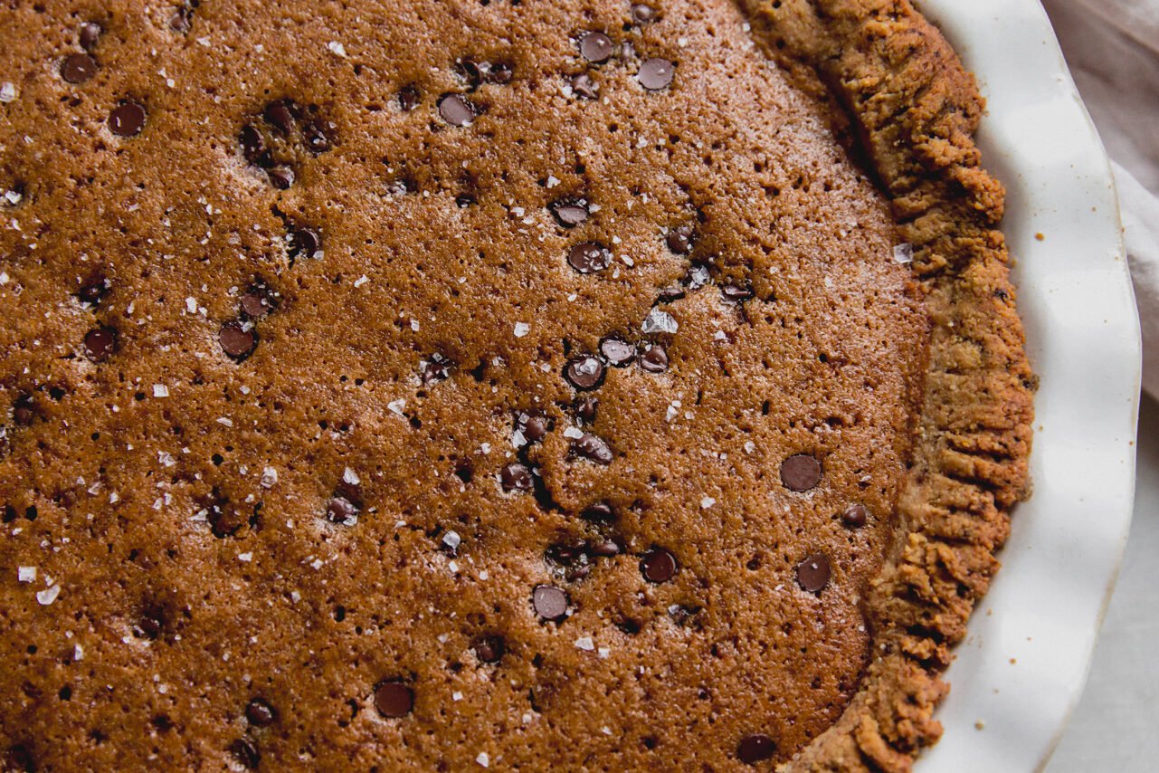 Chocolate chip cookie pit in a large white pie pan.