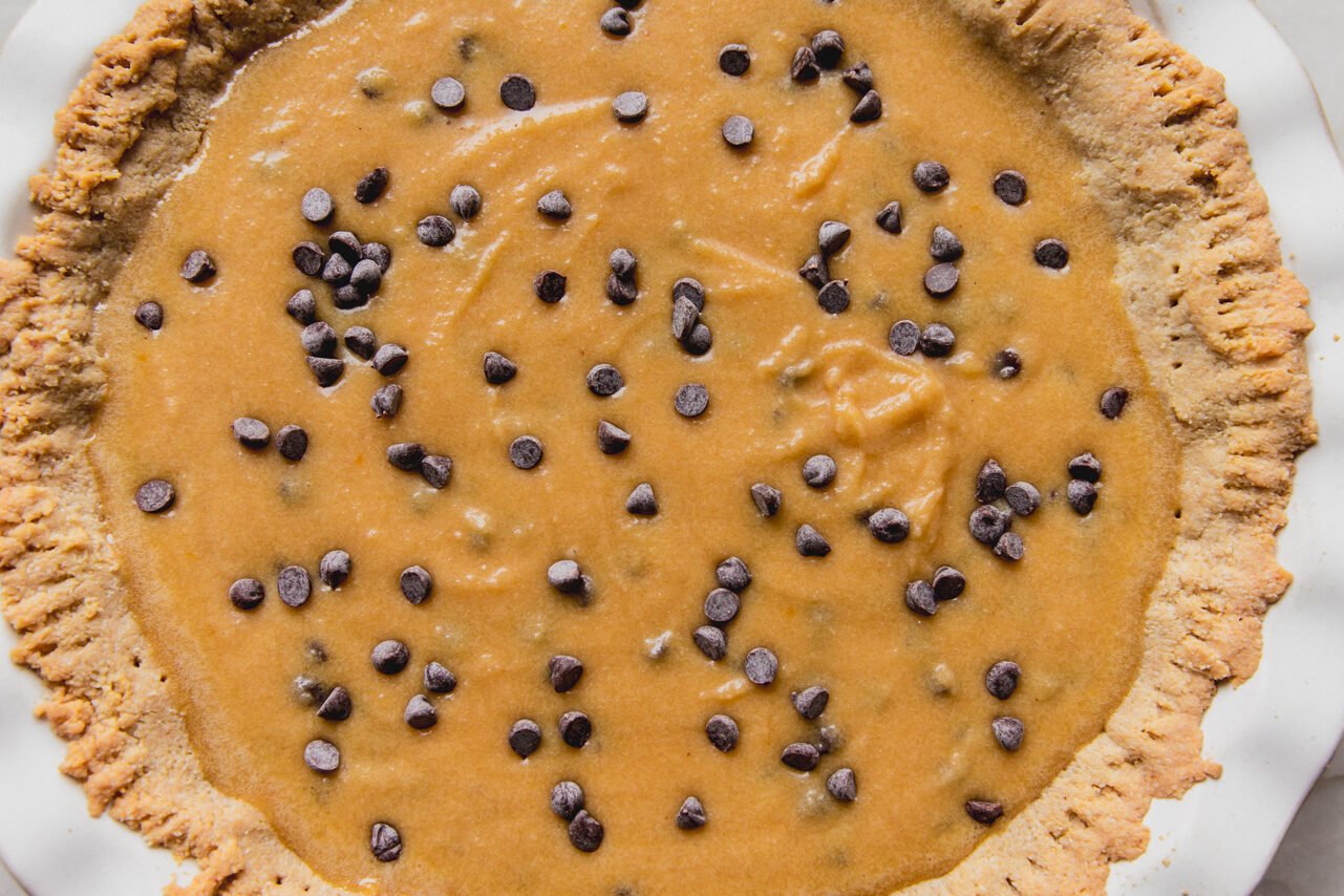 Chocolate chip cookie pie in a large pie pan, unbaked.