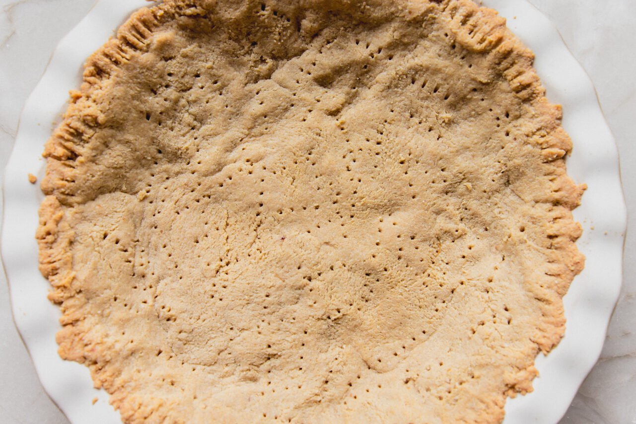 Almond flour pie crust baked in a pie pan.
