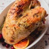 Fully cooked slow cooker turkey breast in a white serving dish.