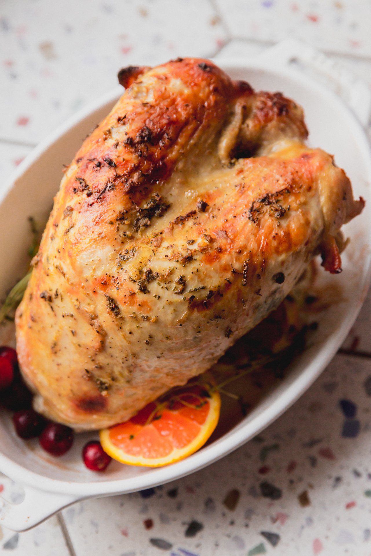 Fully cooked slow cooker turkey breast in a white serving dish.