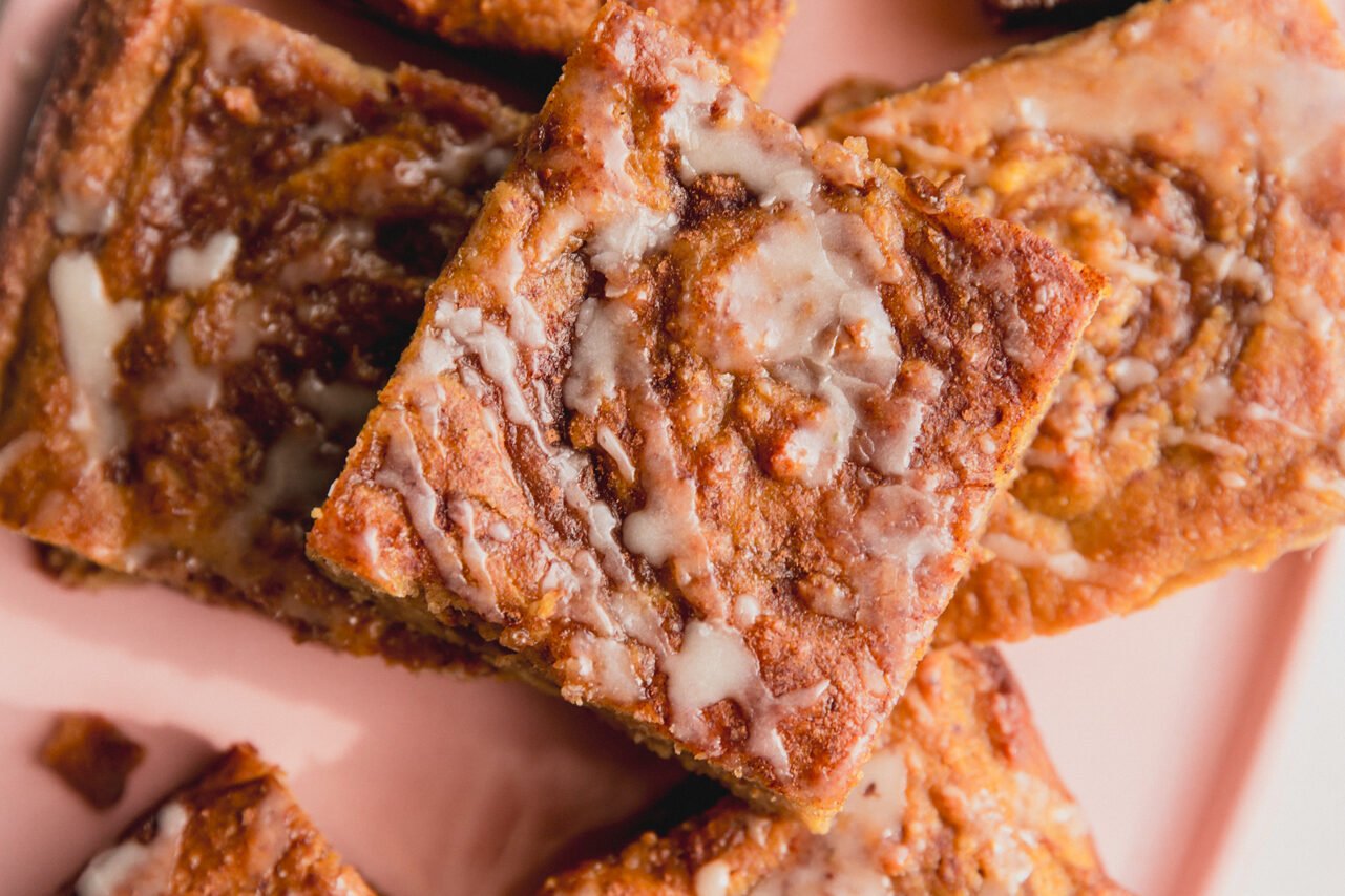 Cut pieces of cinnamon roll cake on a pink plate.