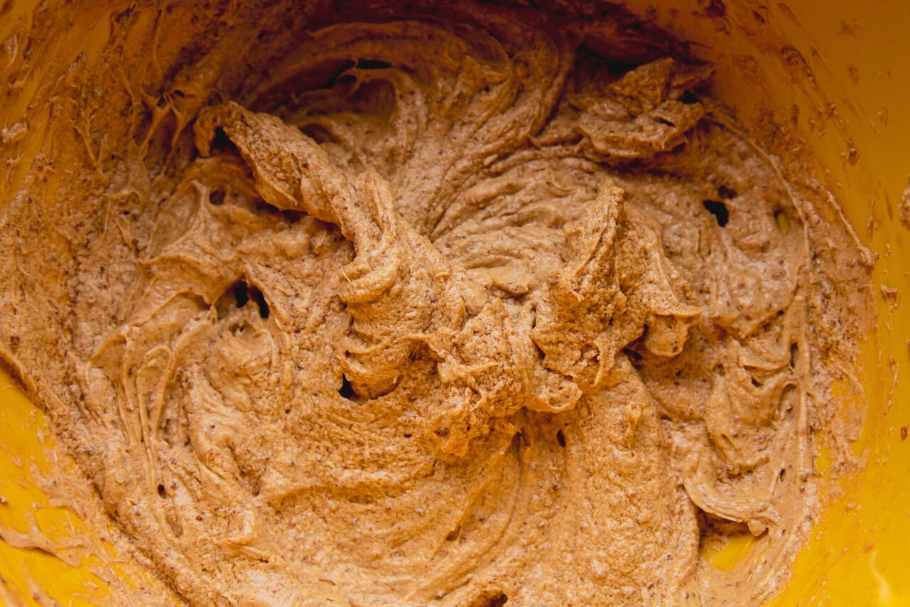 A yellow bowl filled with cookie dough after being mixed.