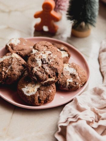 Marhsmallow fluff cookies on a pink plate with mini christmas trees in the background.