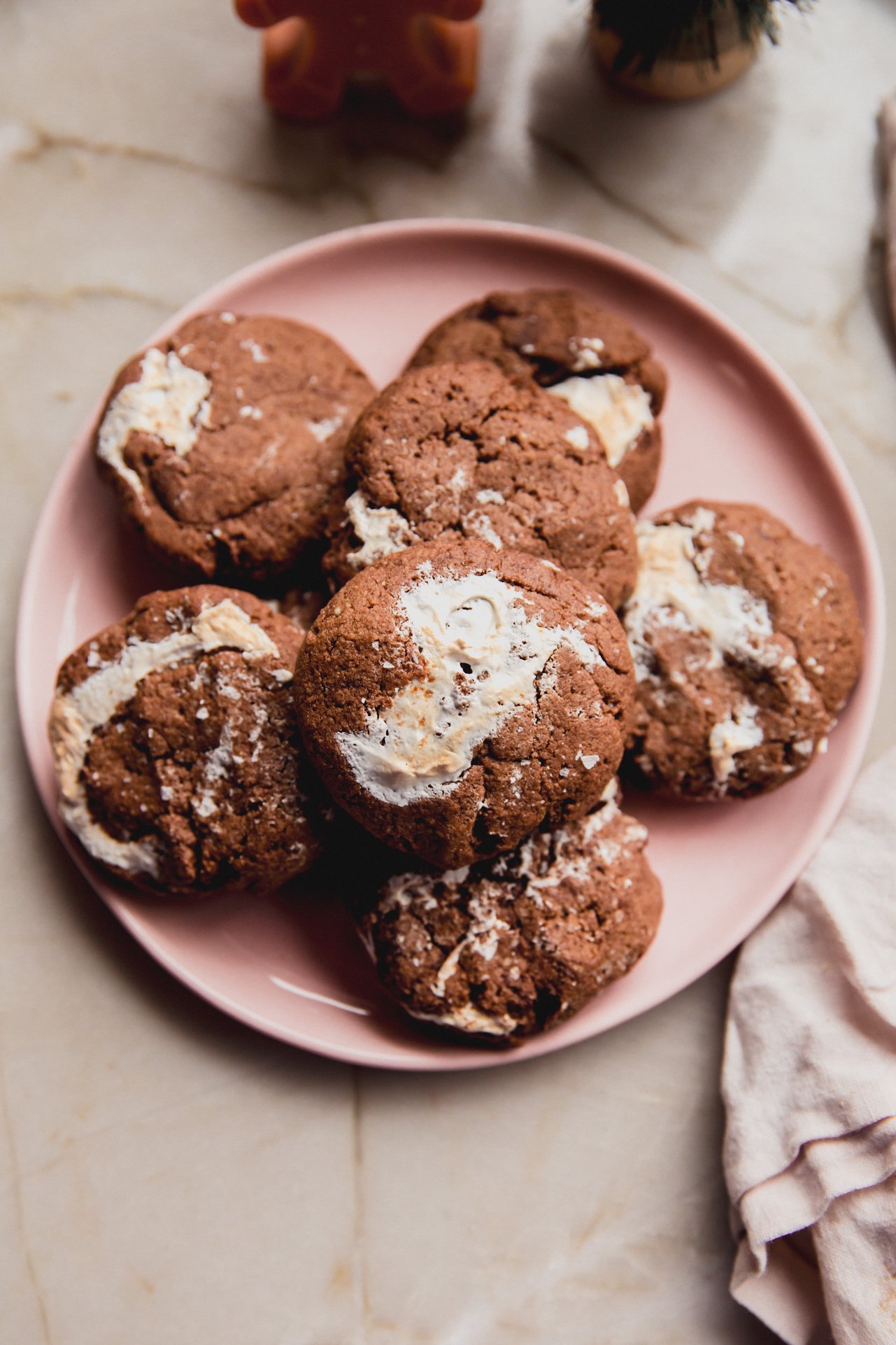 A pink plate stacked with gluten-free chocolate marshmallow cookies.