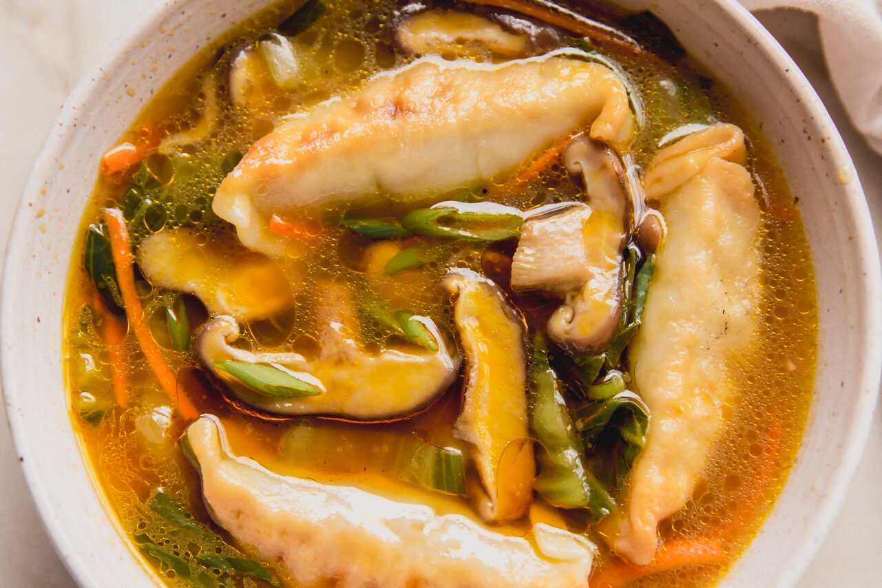 A bowl of potsticker soup before being eaten.