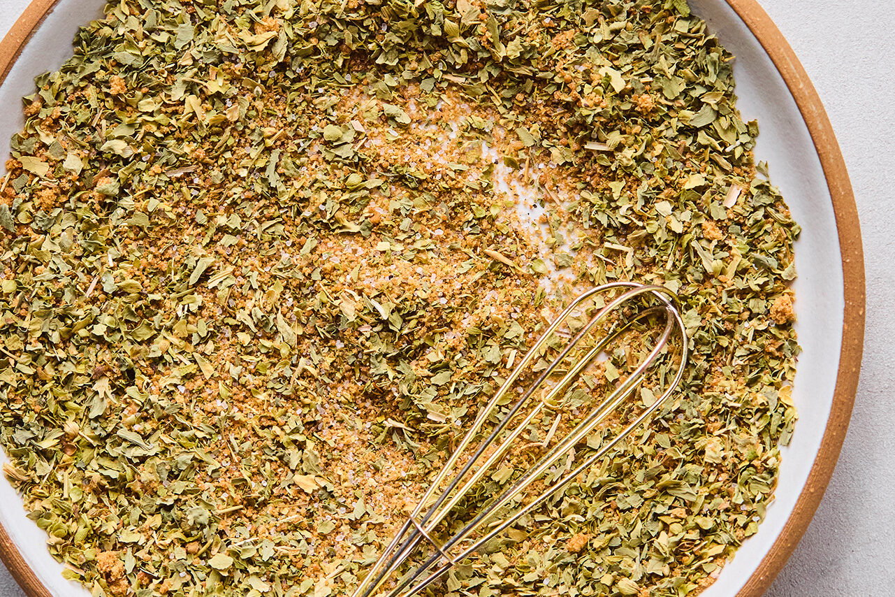 Pork shoulder spice rub in a bowl with a whisk.