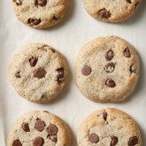 AIP chocolate chip cookies fully baked on a baking sheet with white parchment paper.