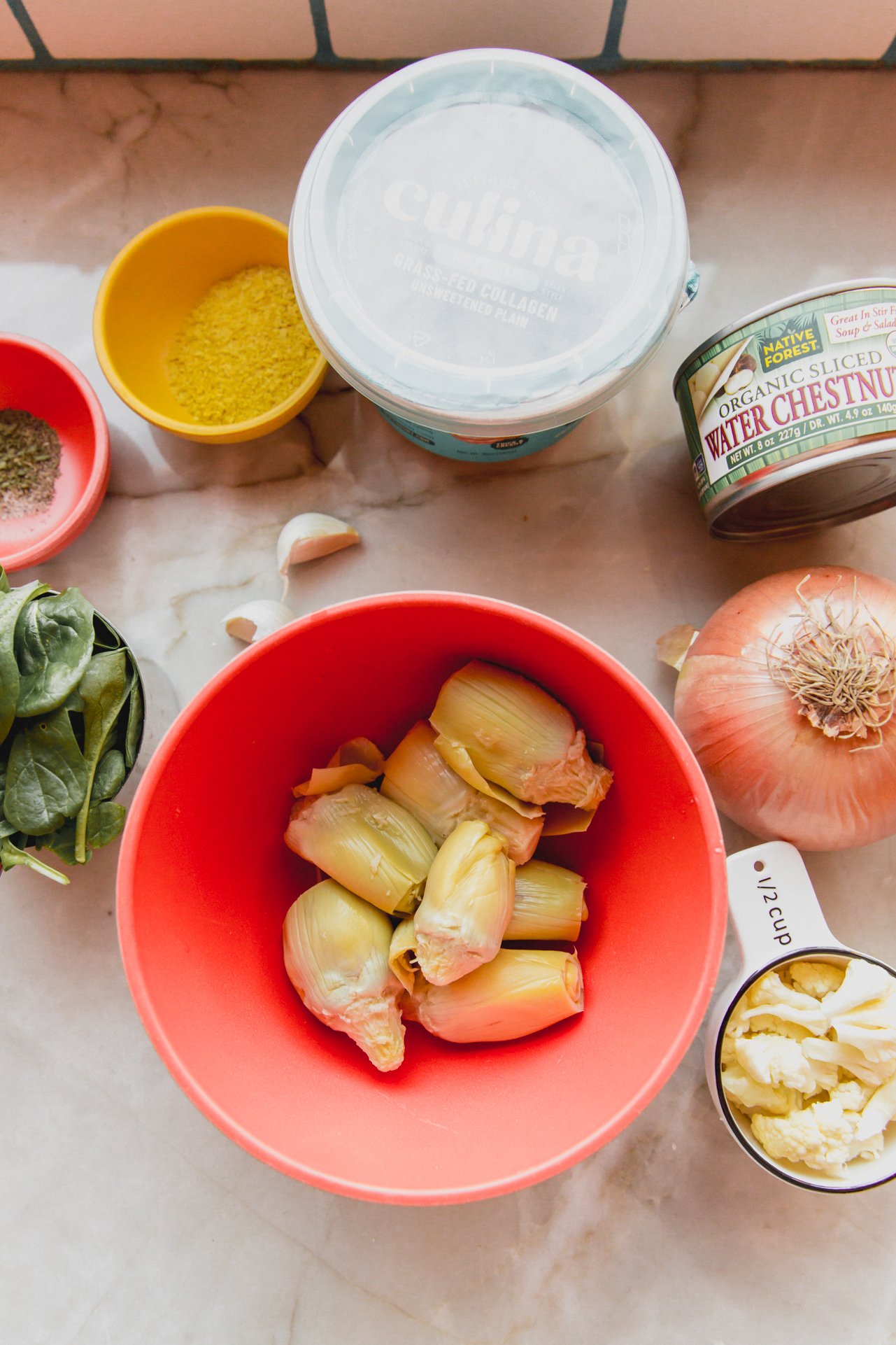 All the ingredients needed to make spinach & artichoke dip laid out on a counter before cooking.