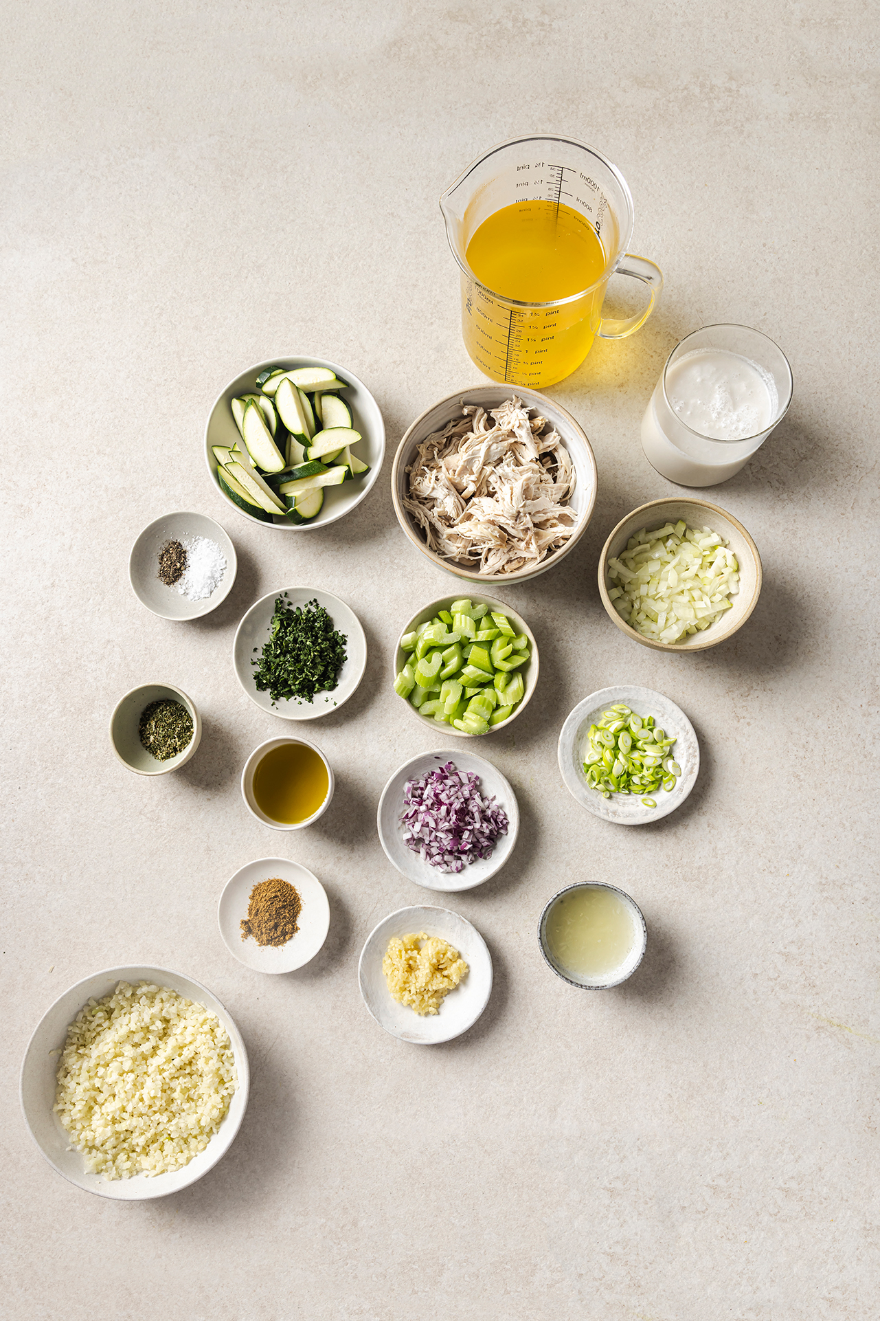 All the ingredients needed to make white chicken chili all laid out in bowls.