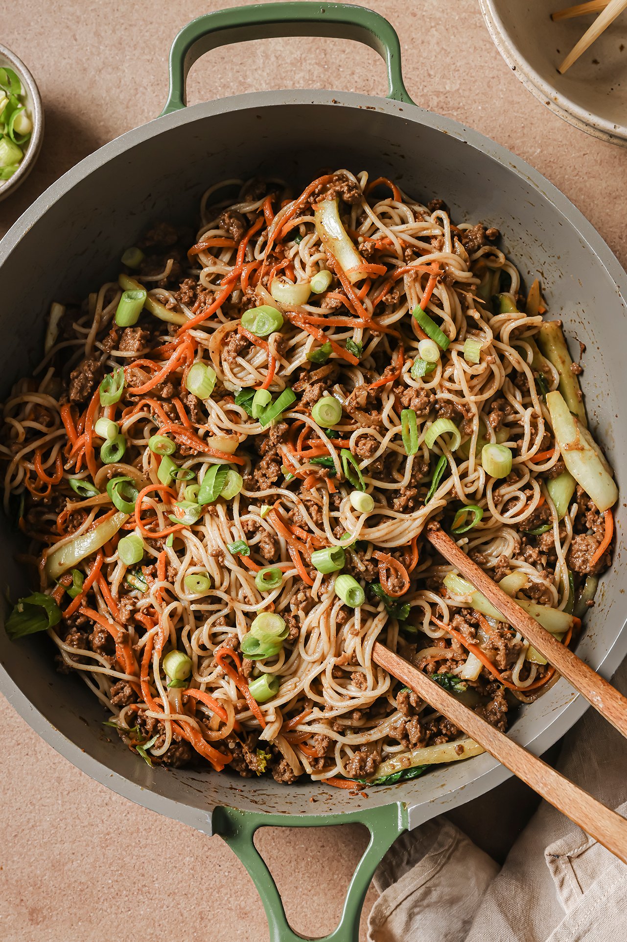 A pan with hoisin beef noodles after cooking with chopsticks in the pan.