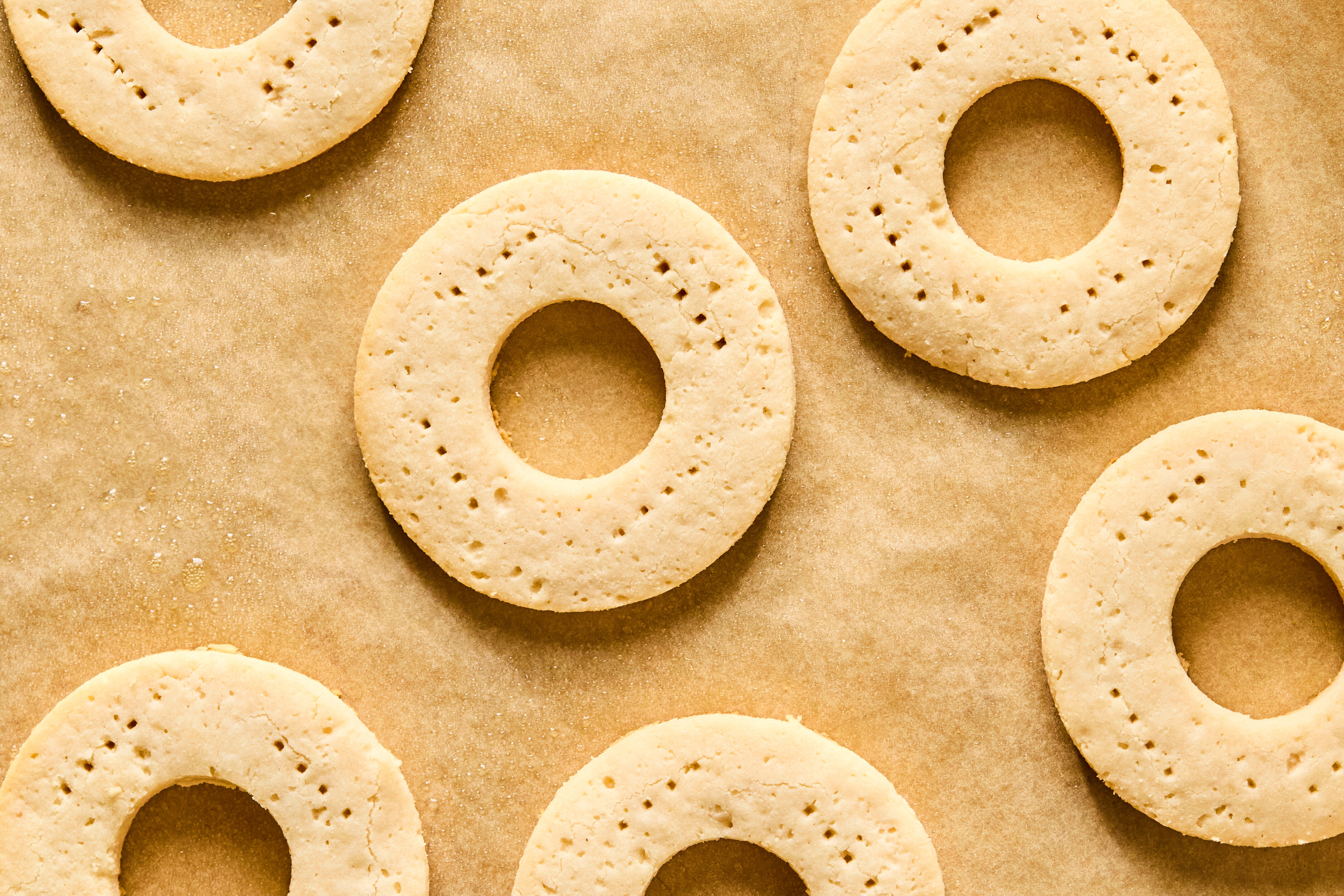 Baked dough circles on parchment paper after coking out of the oven.