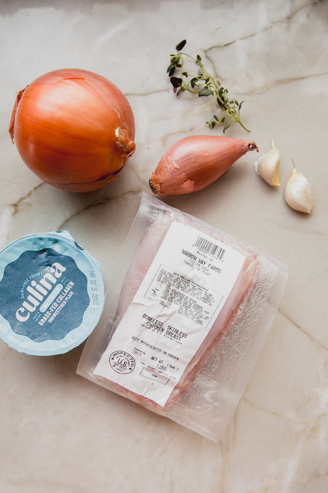 All the ingredients for french onion chicken salad on a marble countertop before cooking.