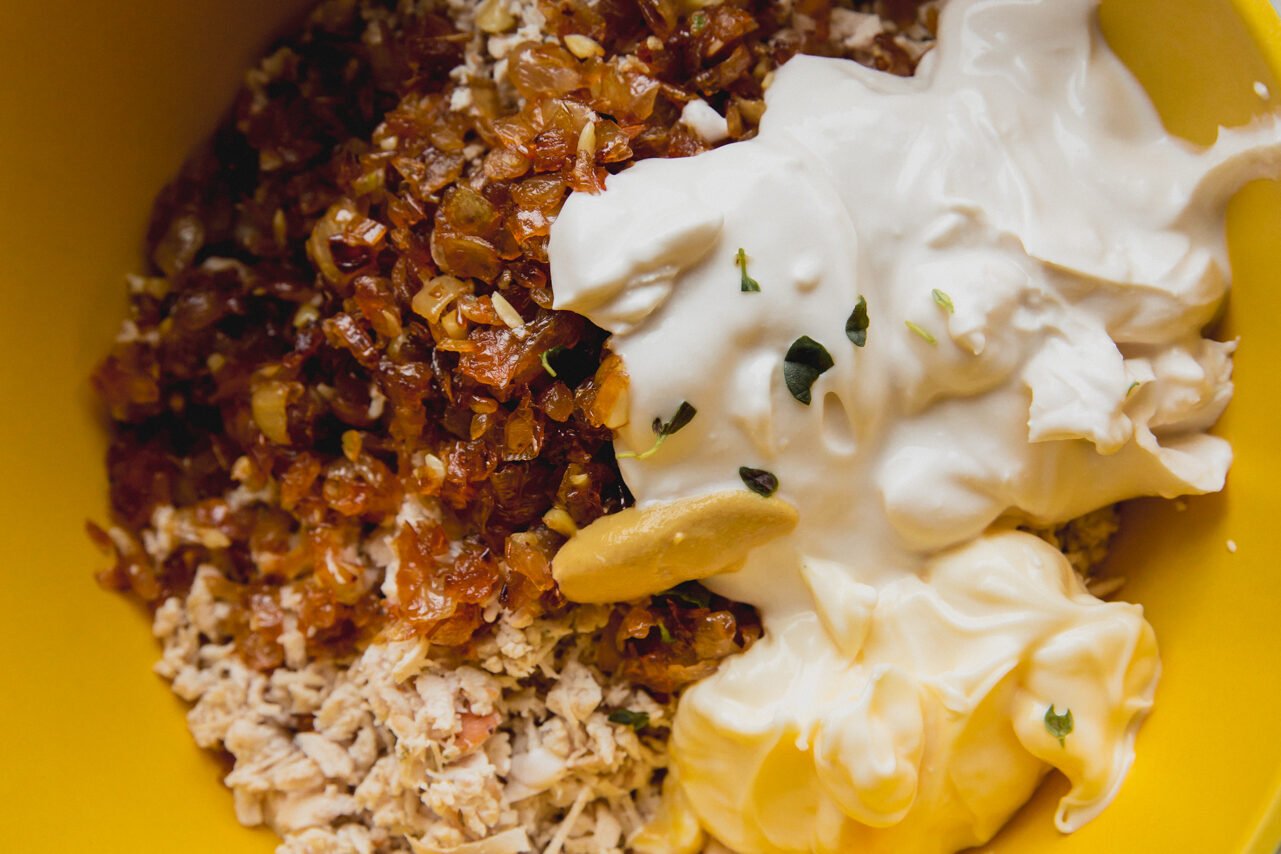 All the ingredients for the chicken salad in a yellow bowl before combining.