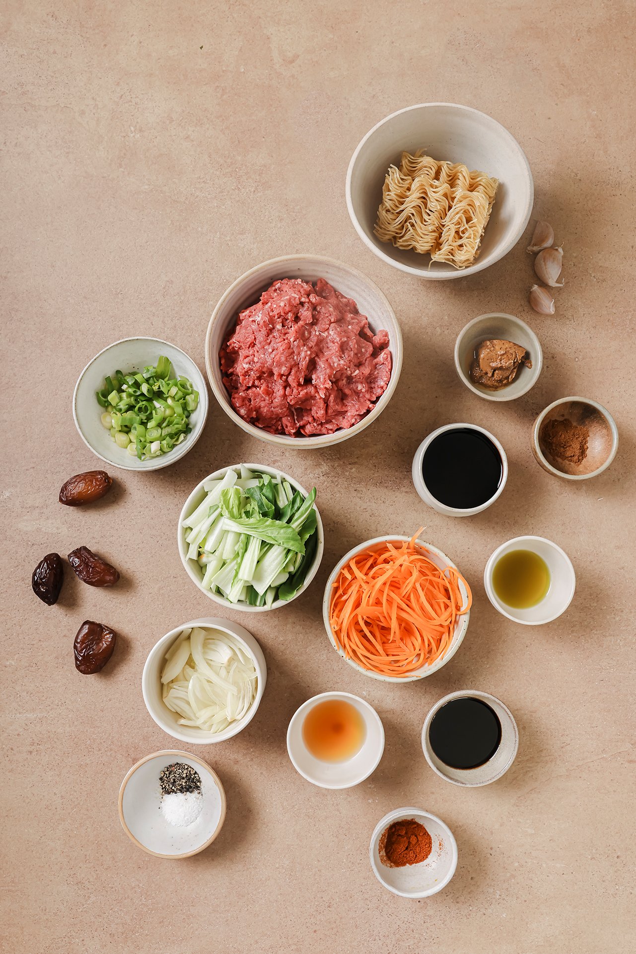 All the ingredients for the hoisin beef noodles in white bowls on the counter before cooking.