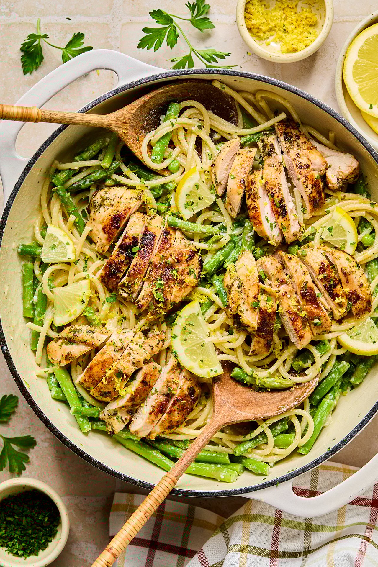 A put of lemon goat cheese pasta after cooking with a wooden serving spoon in it.
