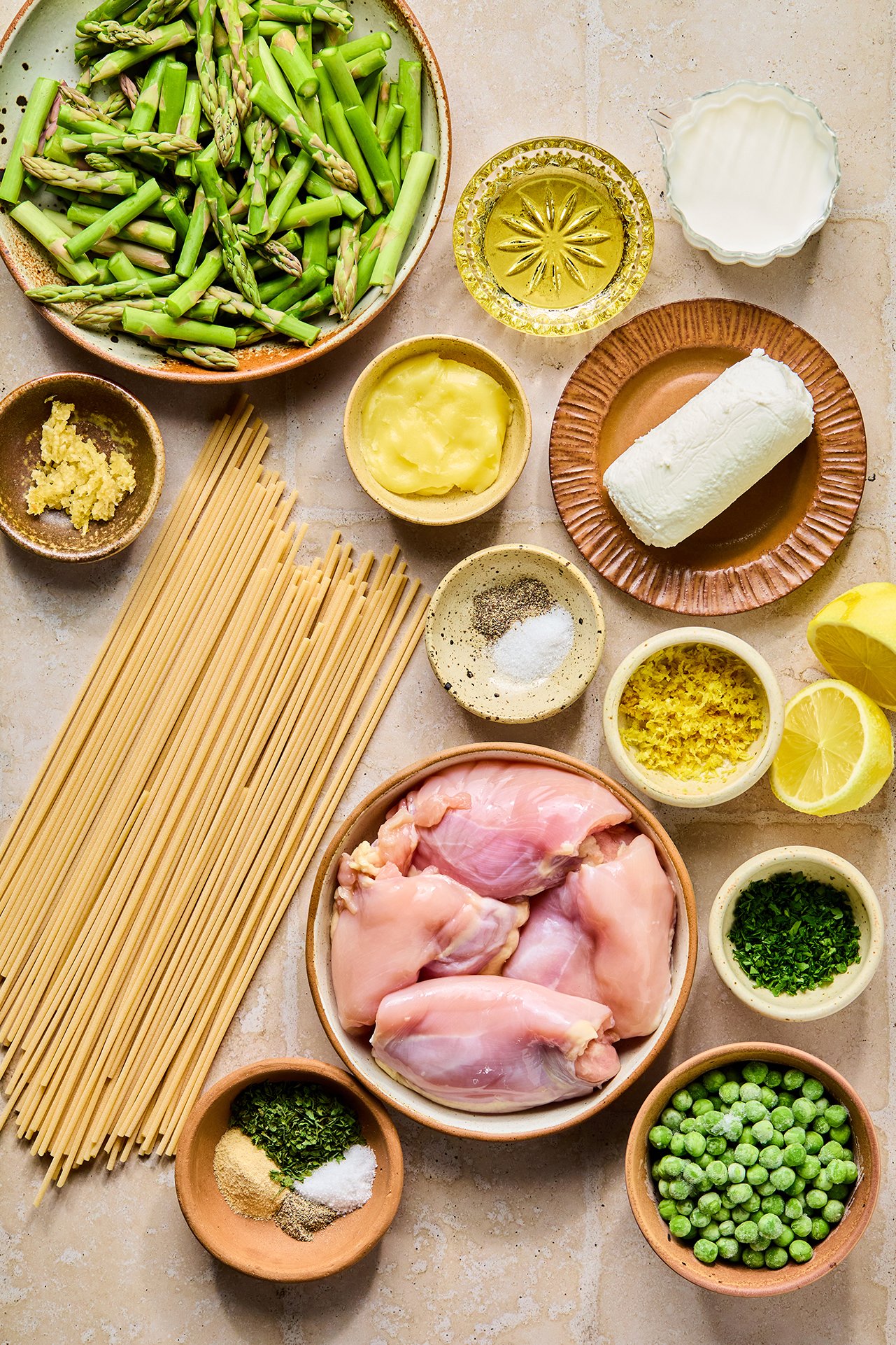 All the ingredients to make lemon goat cheese pasta in bowls on a counter before cooking.
