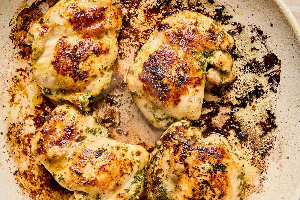 Chicken searing in a pan.
