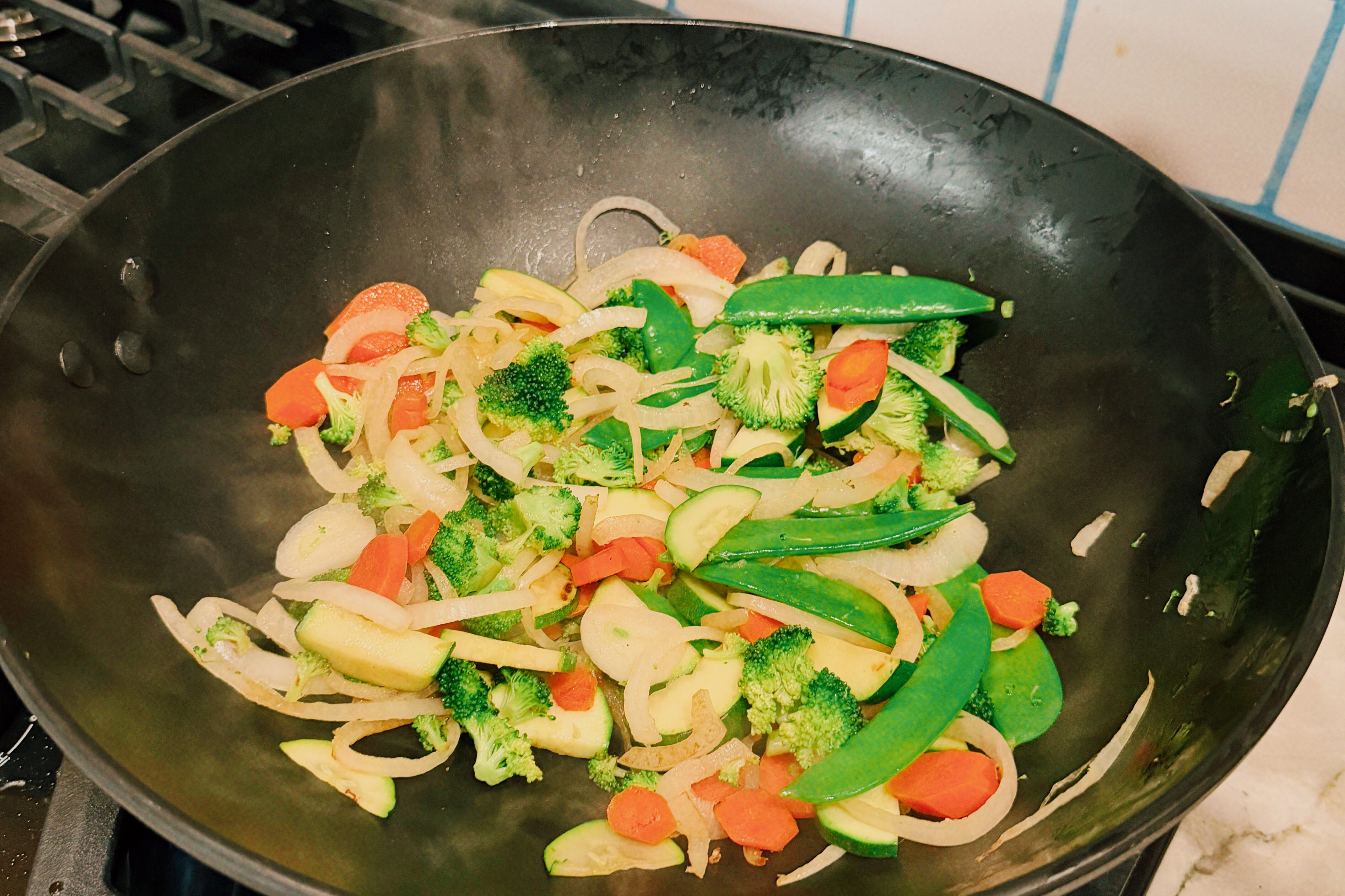 The veggies in a wok sauting.