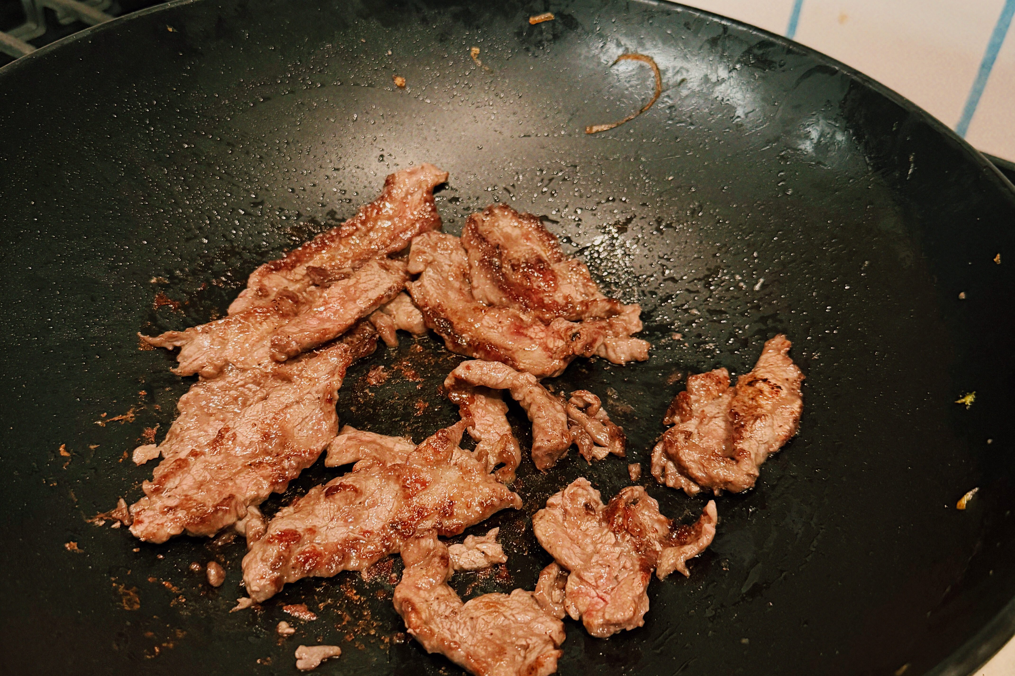 The beef cooking in a wok.