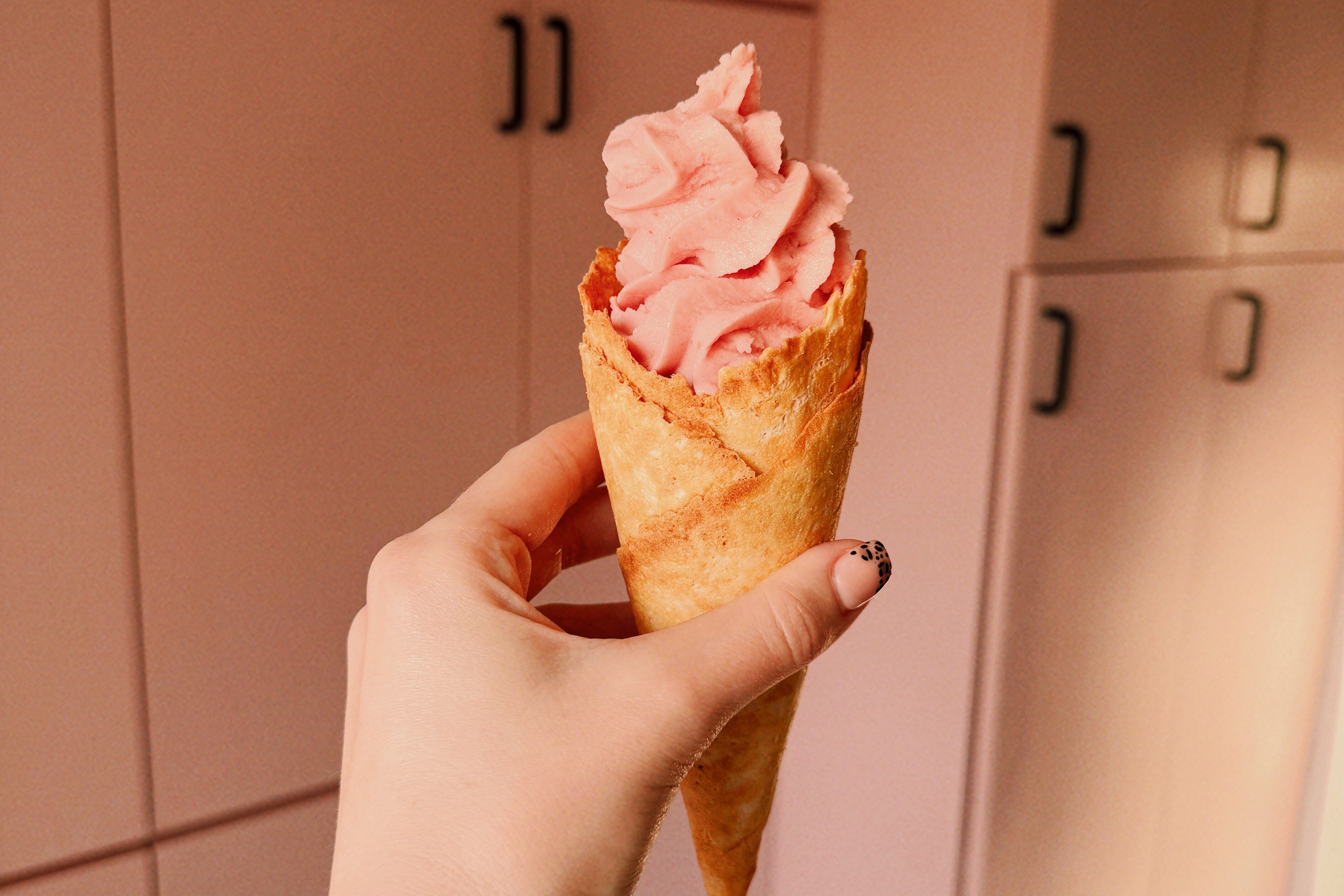 A cone filled with strawberry ice cream made in the ninja creami.