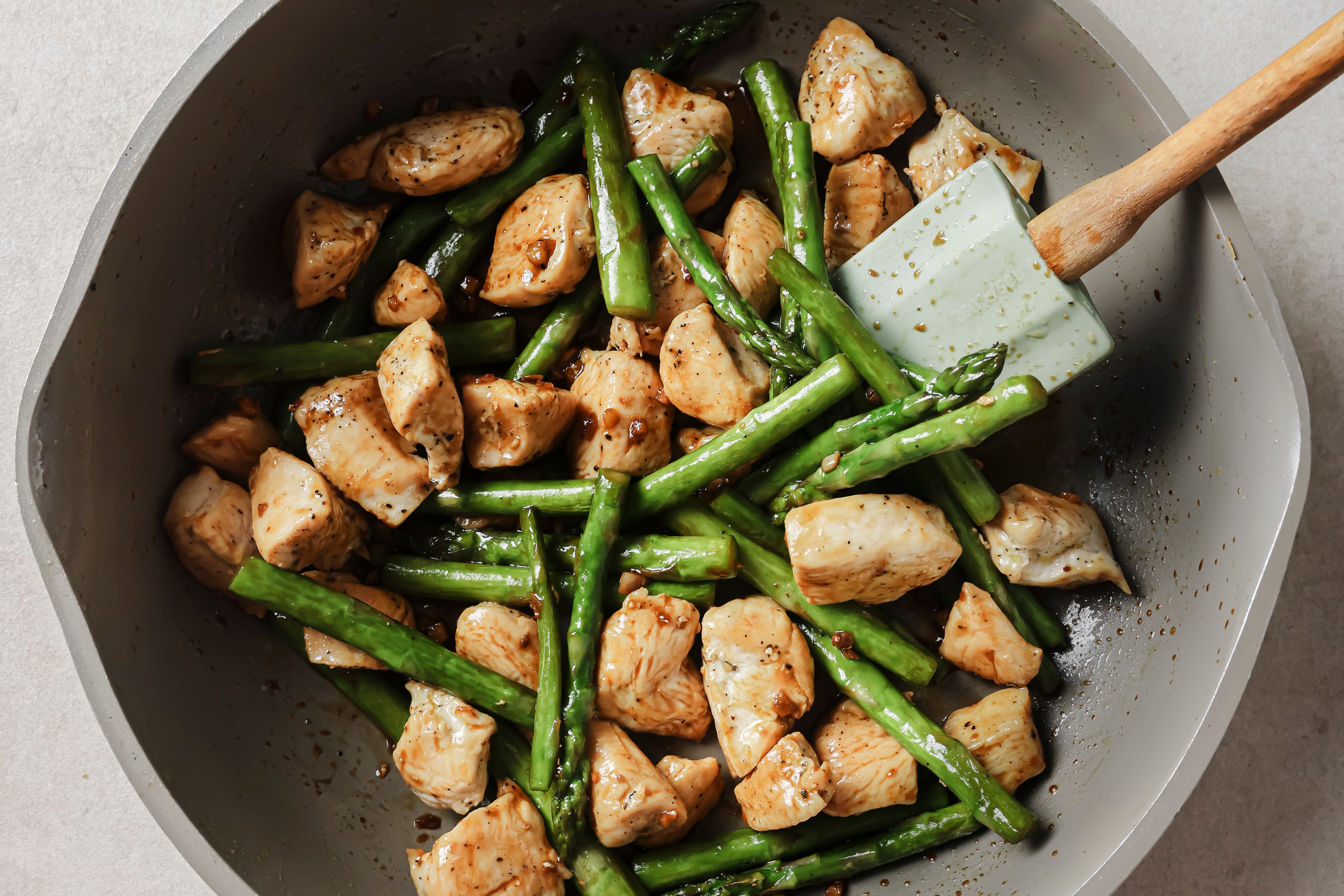 All the ingredients warming and combining in a pan with a spatula stirring it.