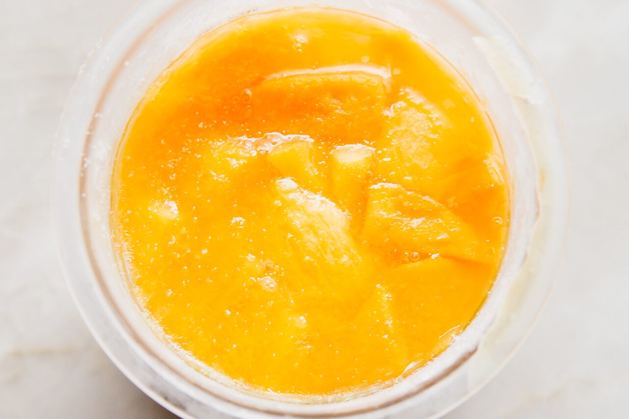 Mango and orange juice frozen in a ninja creami container.