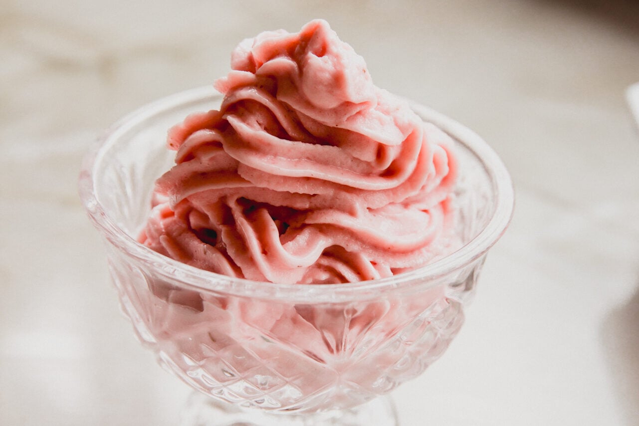 A glass bowl filled with strawberry ice cream made in the ninja creami.