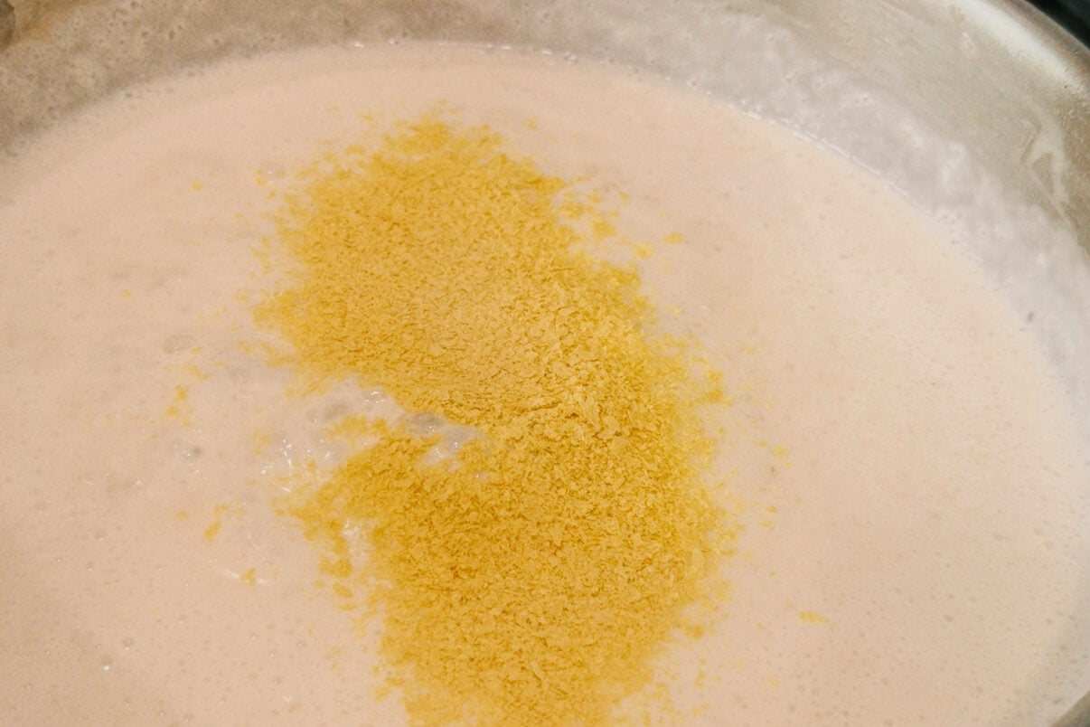 A stainless steel pan with the roux mixture in it after cooking.