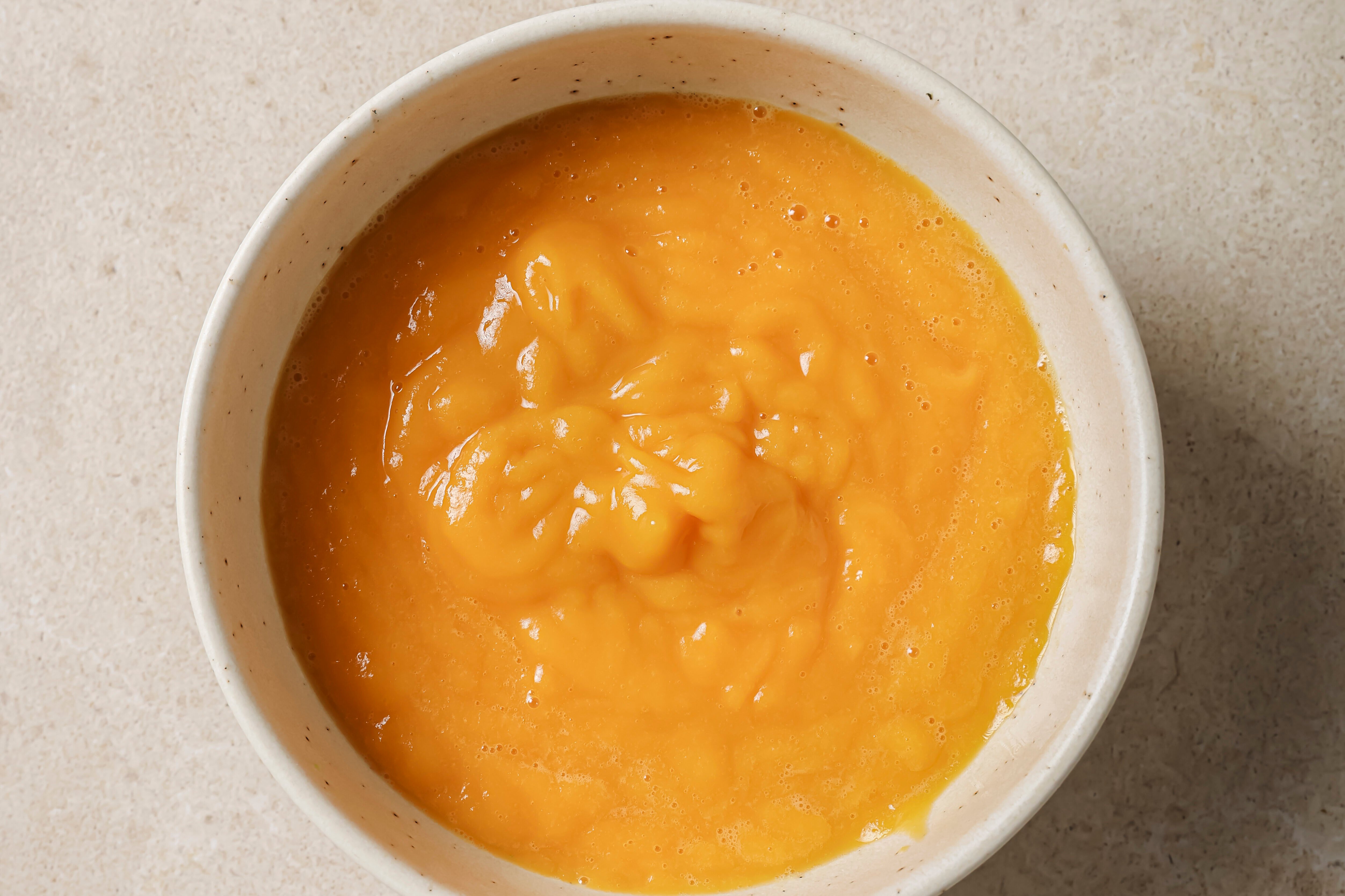 A white bowl filled with the fruit and vegetable mixture after blending.