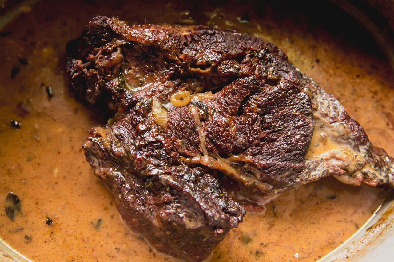 The Dutch oven filled with the chuck roast with vinegar added in.