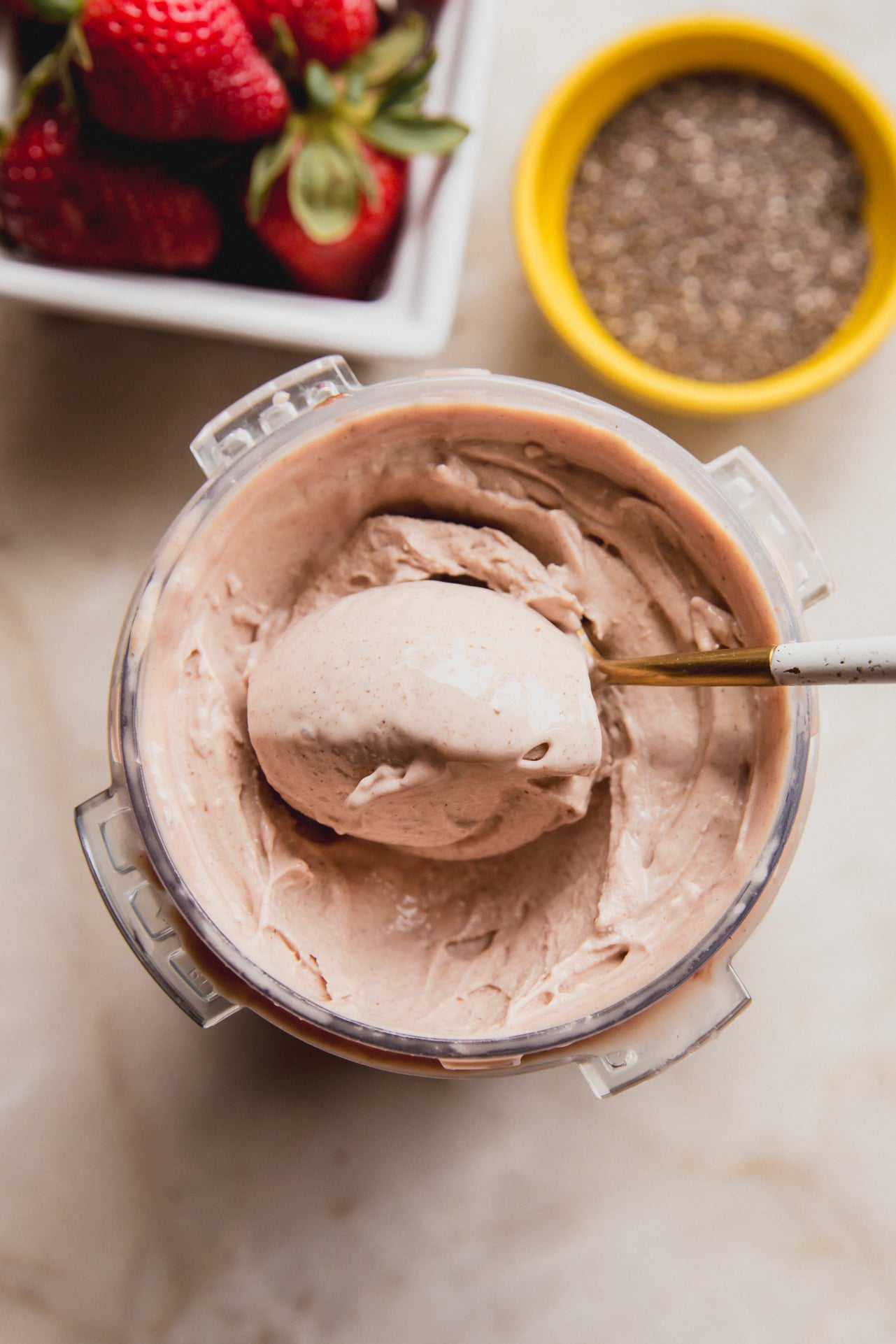 A overhead shot of the Ninja Creami pint of chia seed ice cream with a spoon taking a spoonful out.