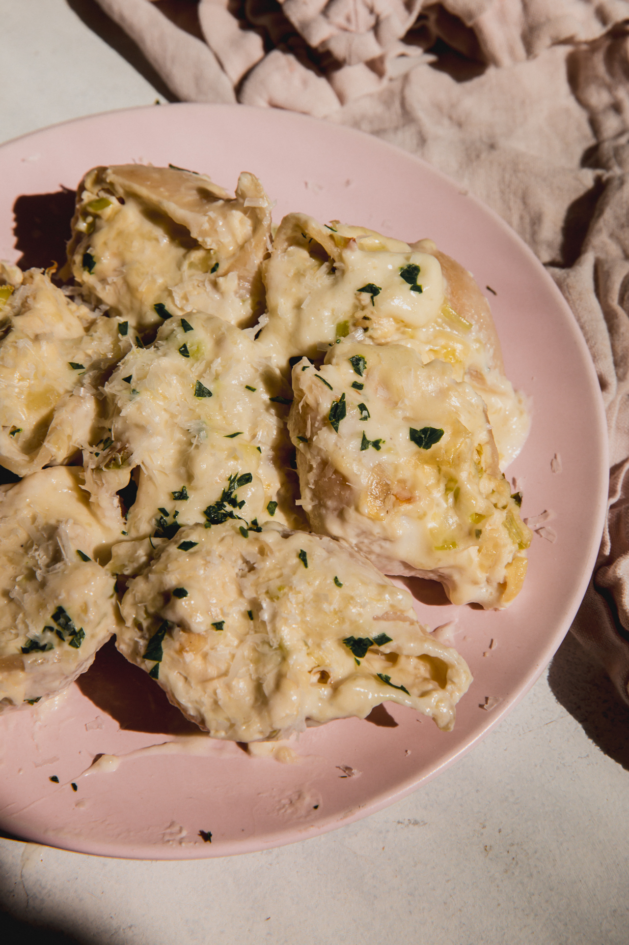 A pink plate filled with several stuffed shells.