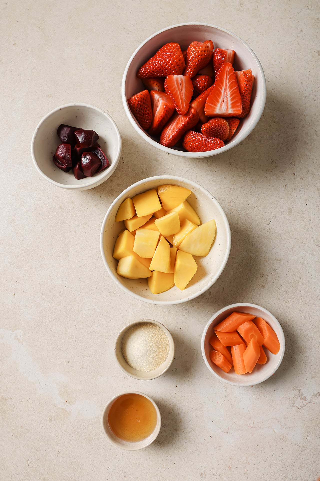 White bowls filled with ingredients for homemade fruit snacks.