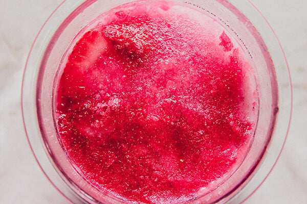 Strawberries, coconut milk and juice in a ninja creami container, fully frozen.