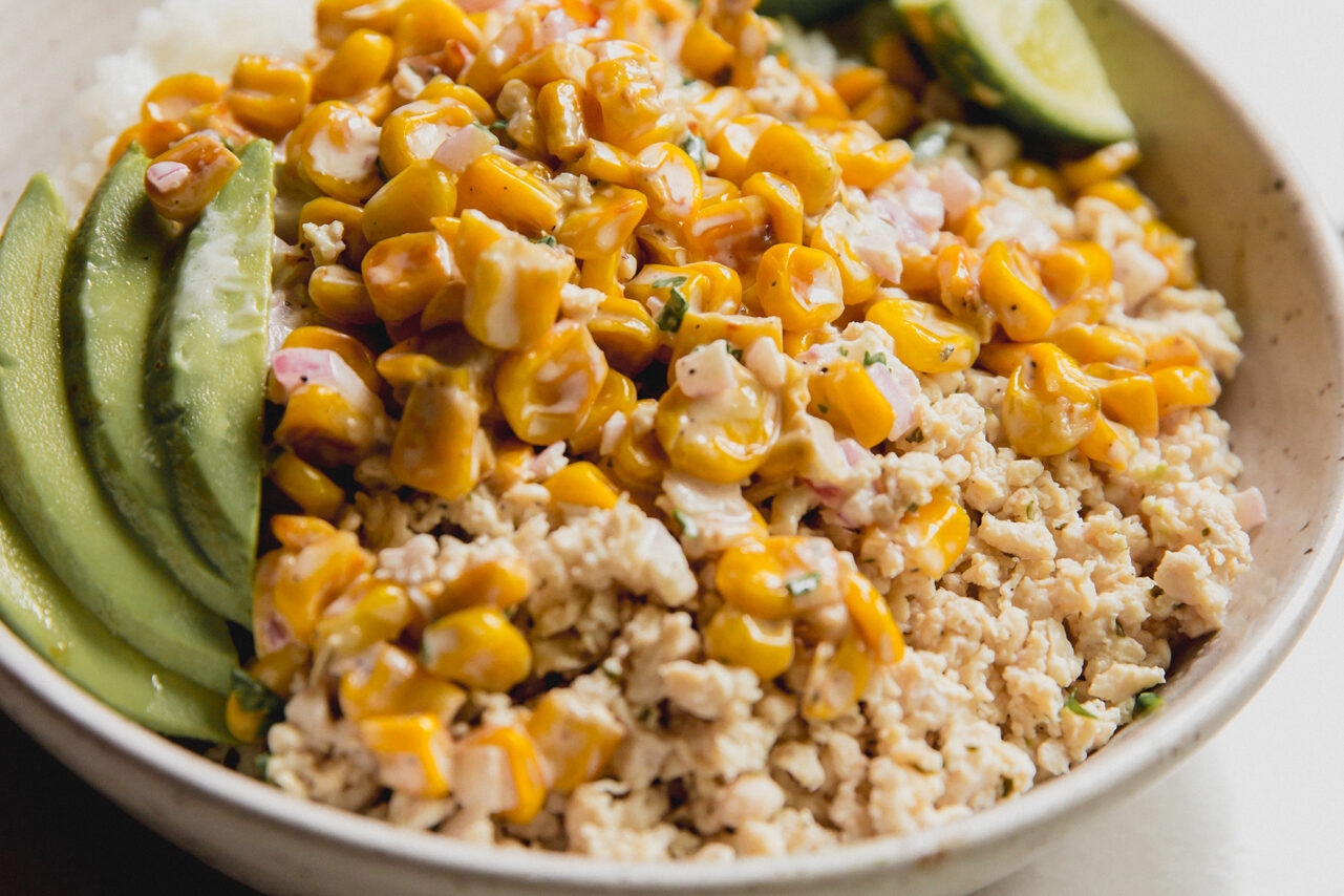 Street corn ground chicken bowl topped with lime and avocado.