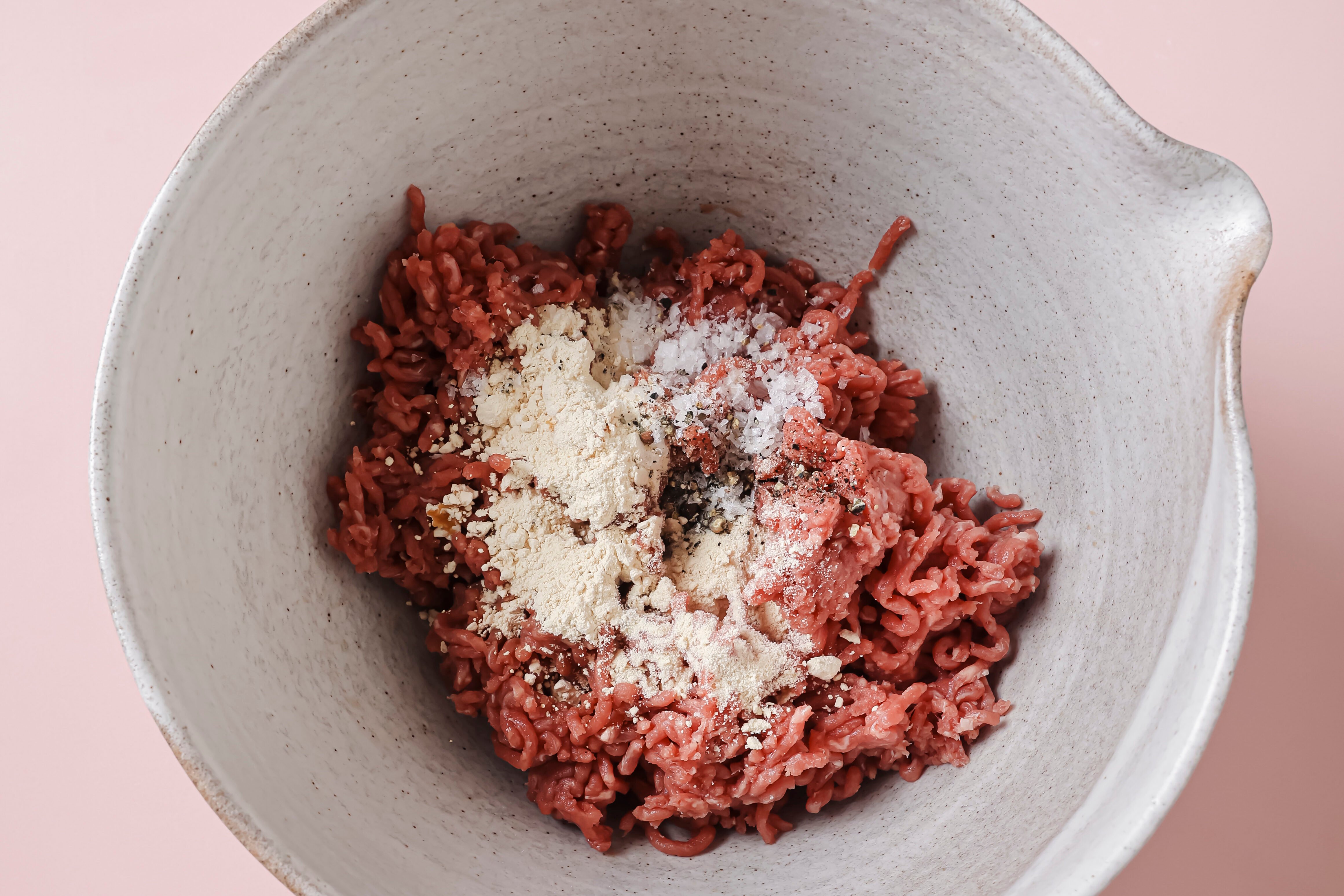 Ground beef and seasonings in a bowl, unmixed.