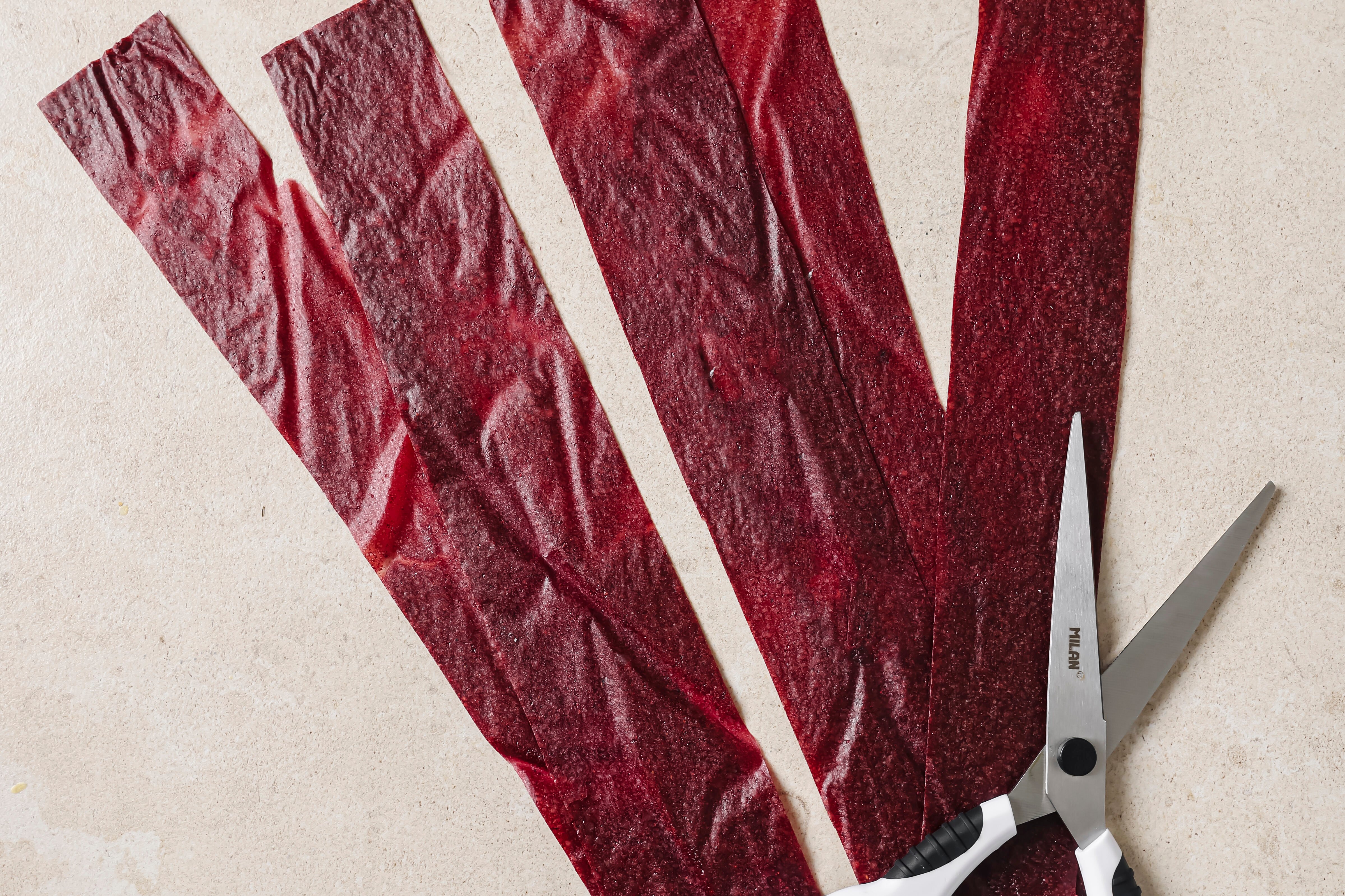 Fruit leather being cut with scissors