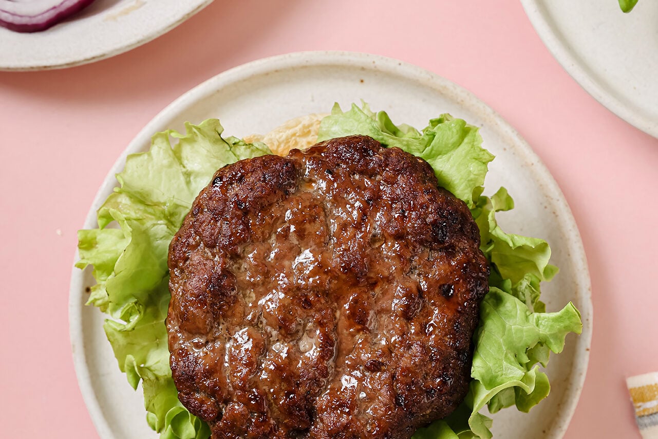 Fully cooked burger on a lettuce wrap.
